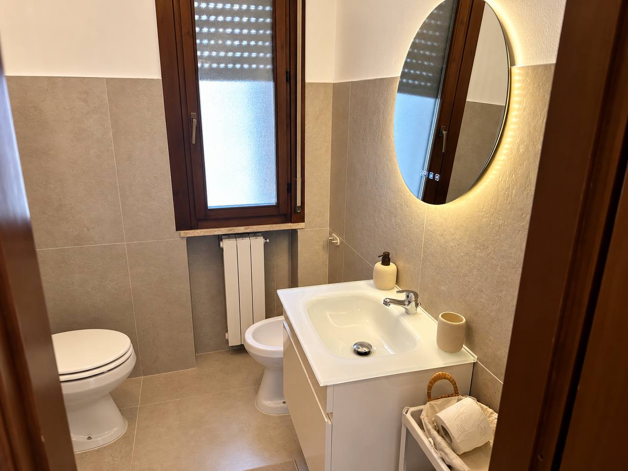 Bathroom with basin and illuminated mirror